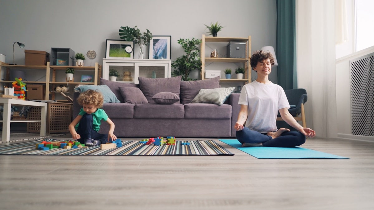 a woman and a child sitting on a rug in a living room